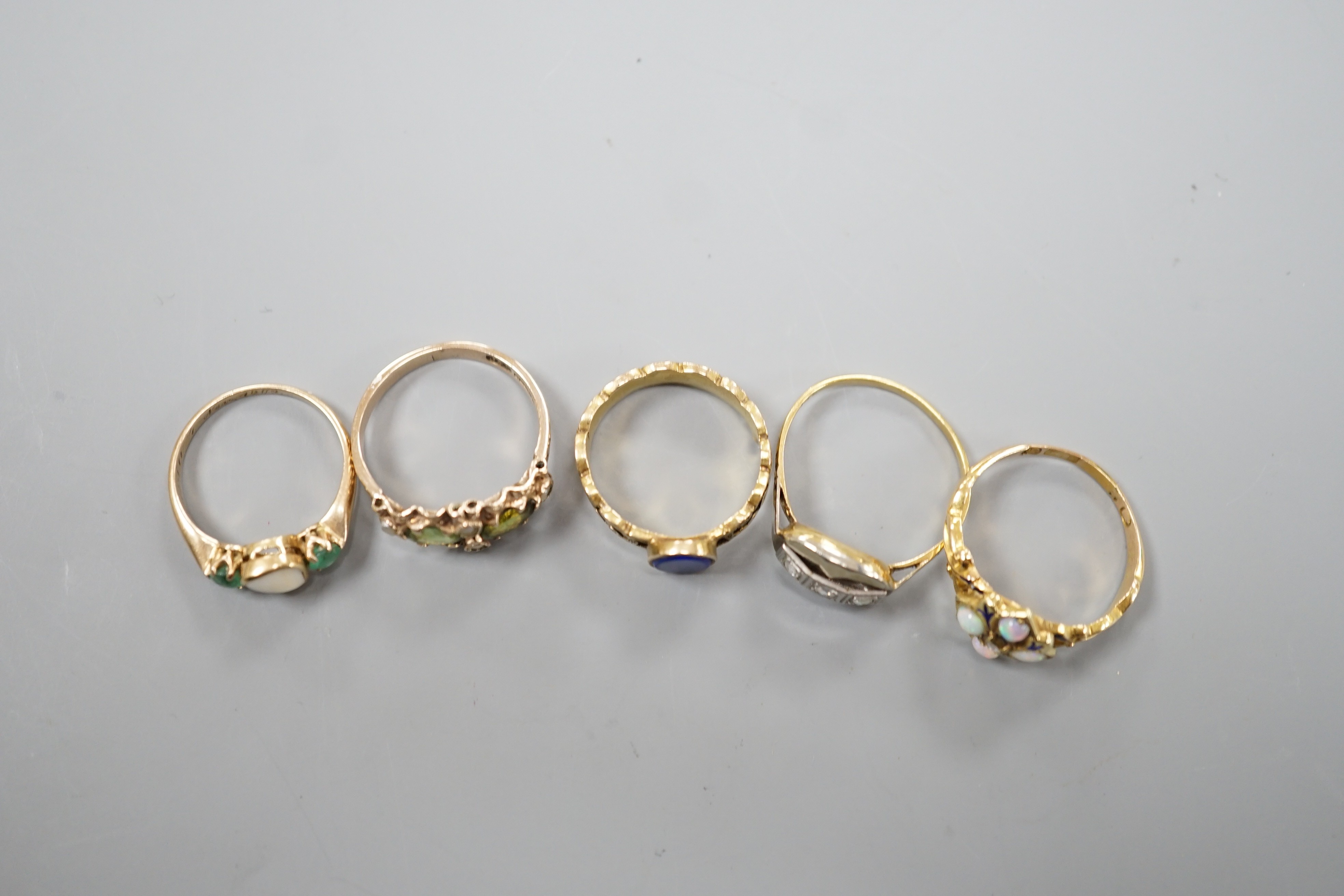 Five assorted early 20th century and later gem set rings, including 15ct white opal and enamel size O, gross weight 2.6 grams, a 585 emerald and white stone ring, gross 2 grams and three others including 9ct gold, gross